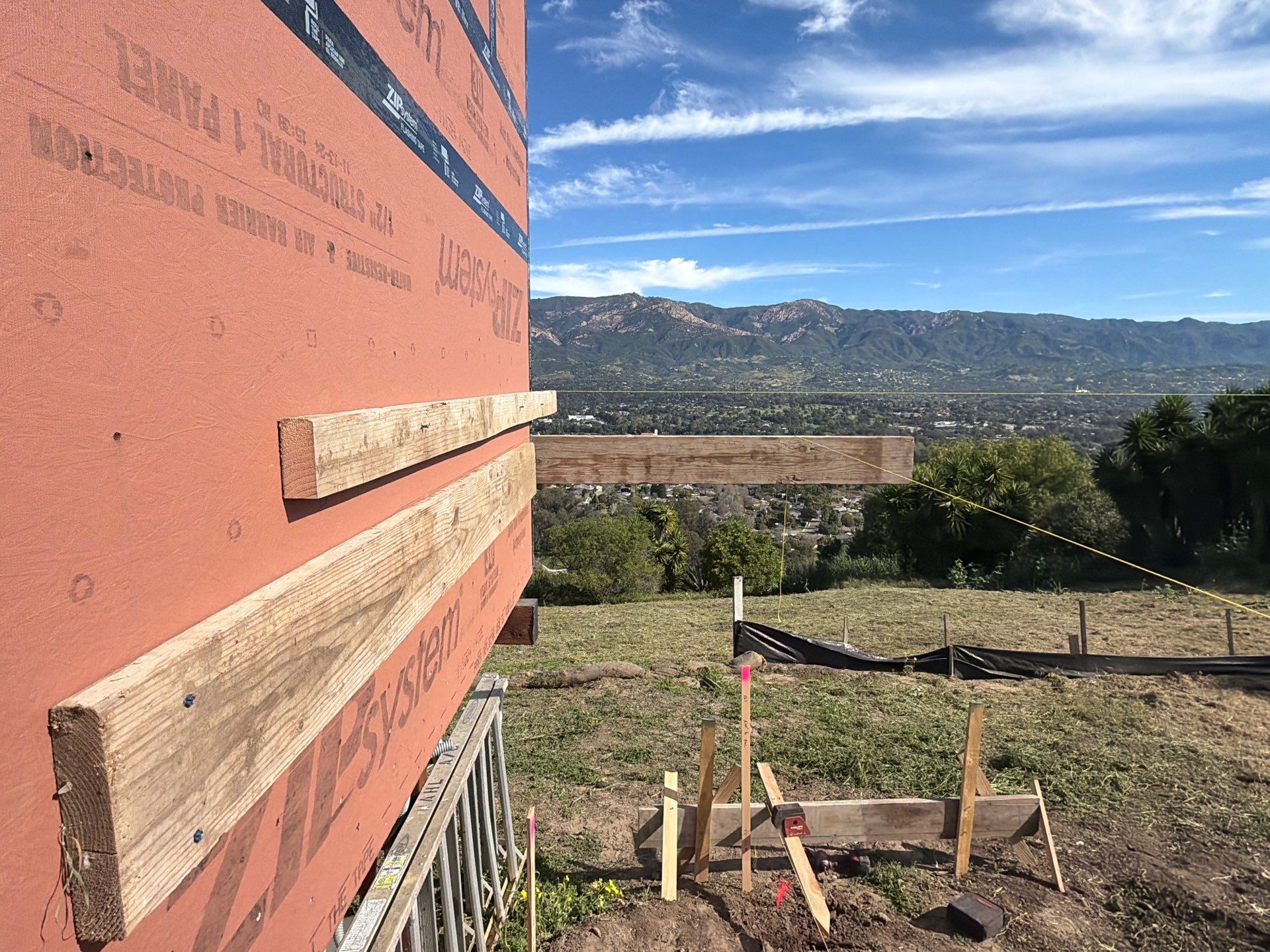 Batterboard attached to the building with a string line running out to the site