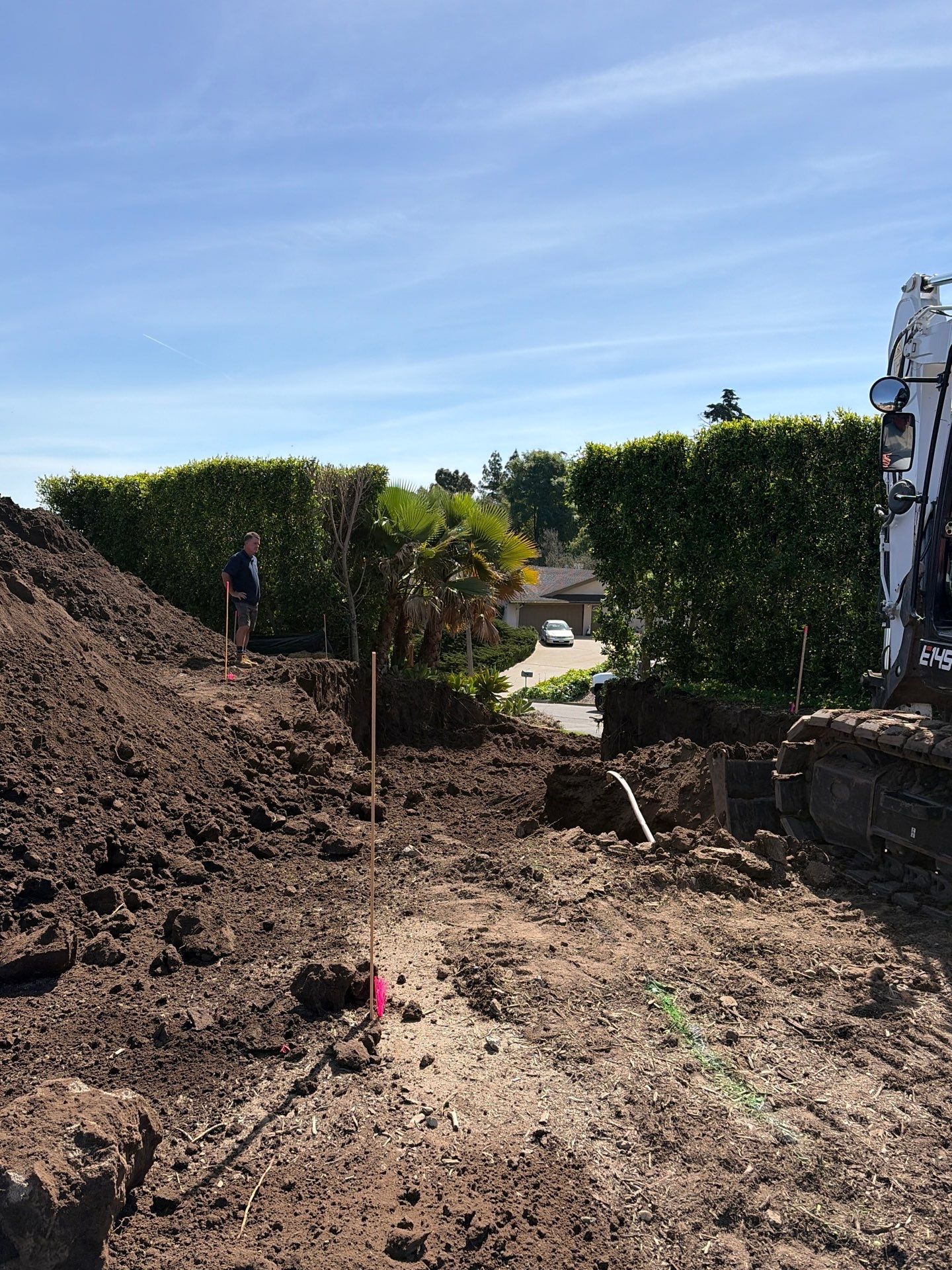 Ground stakes and paint marking overexcavation requirements and finished surface grade