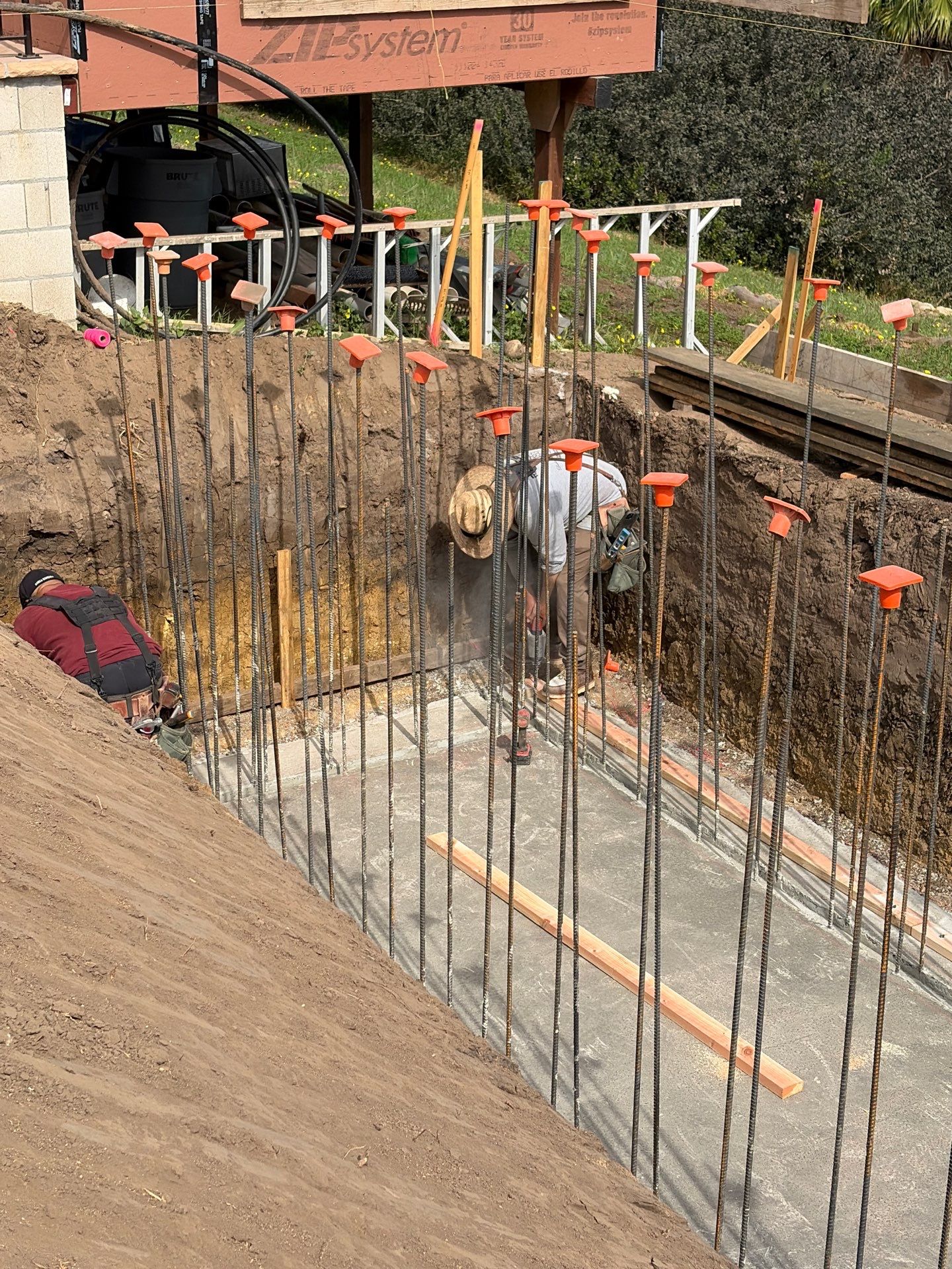 Cleat and strongback assembly with form boards and lateral bracing at cistern wall