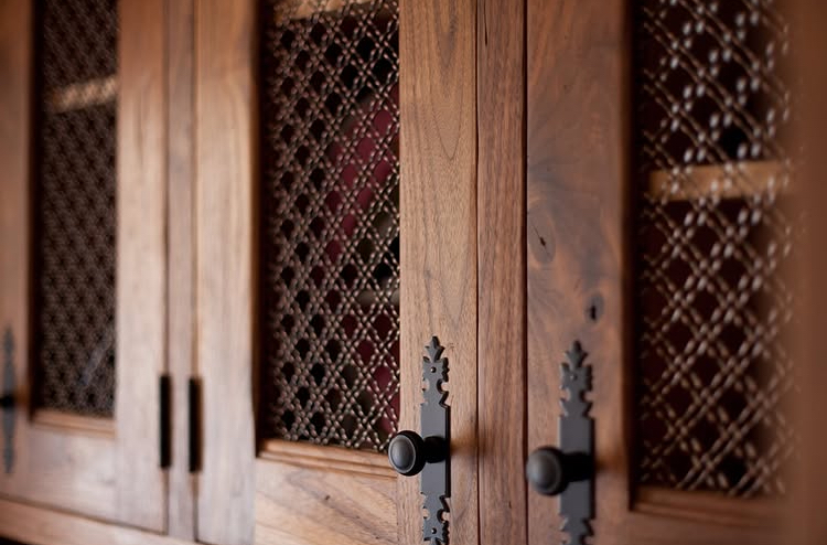 Walnut cabinet doors with lattice detail and iron hardware