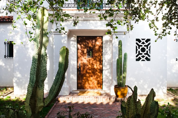 Custom home entrance with wooden door and desert landscaping