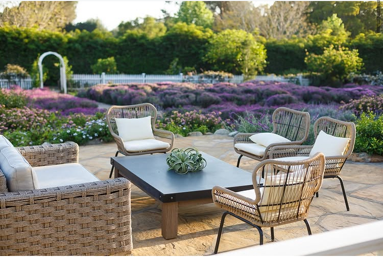 Estate porch with wicker seating and lush garden views