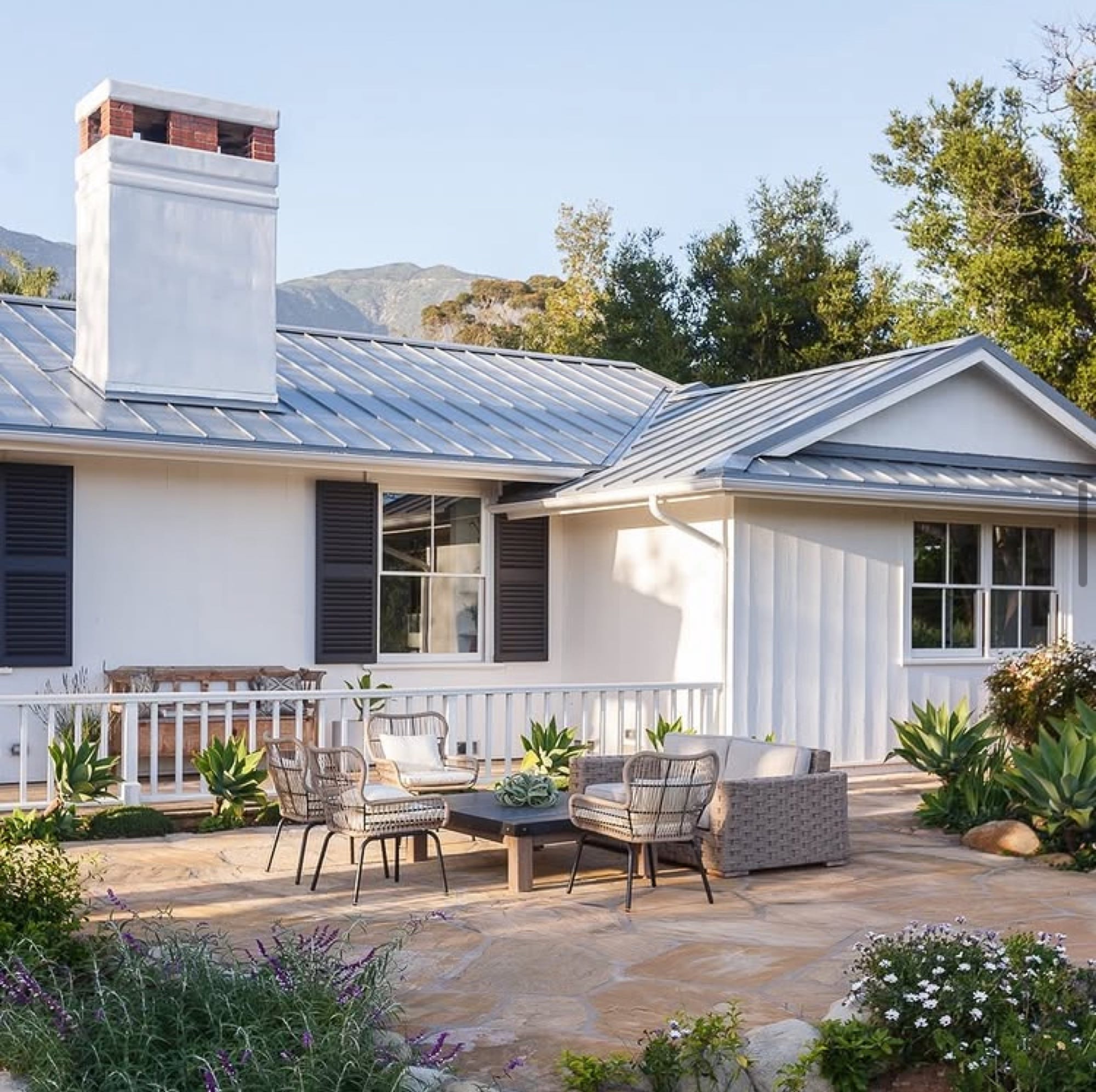 Modern farmhouse with metal roof and stone patio in Santa Barbara