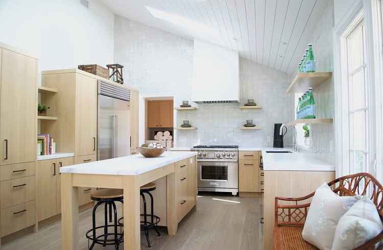 Open kitchen with oak cabinetry, marble island, and shiplap ceiling