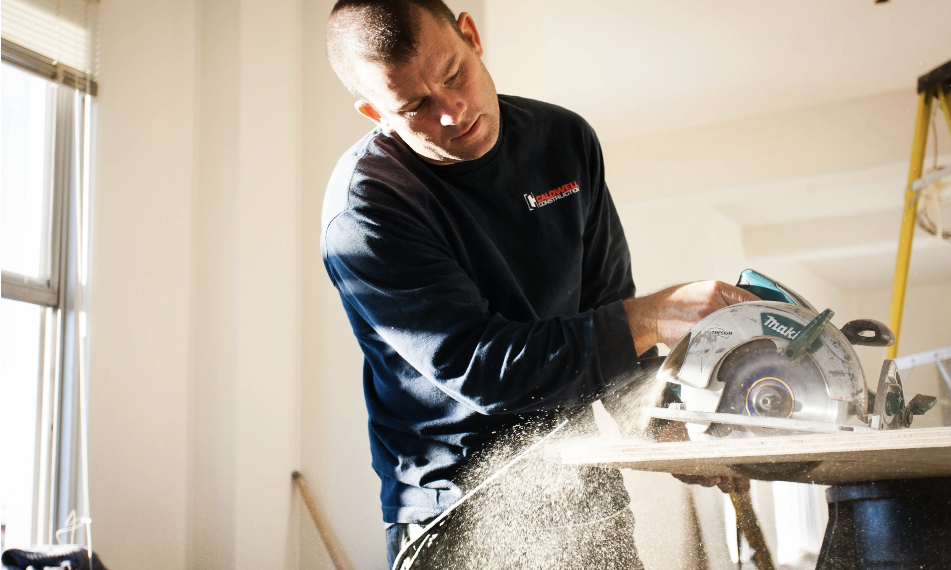 Sean Caldwell cutting material on site in Caldwell Construction gear